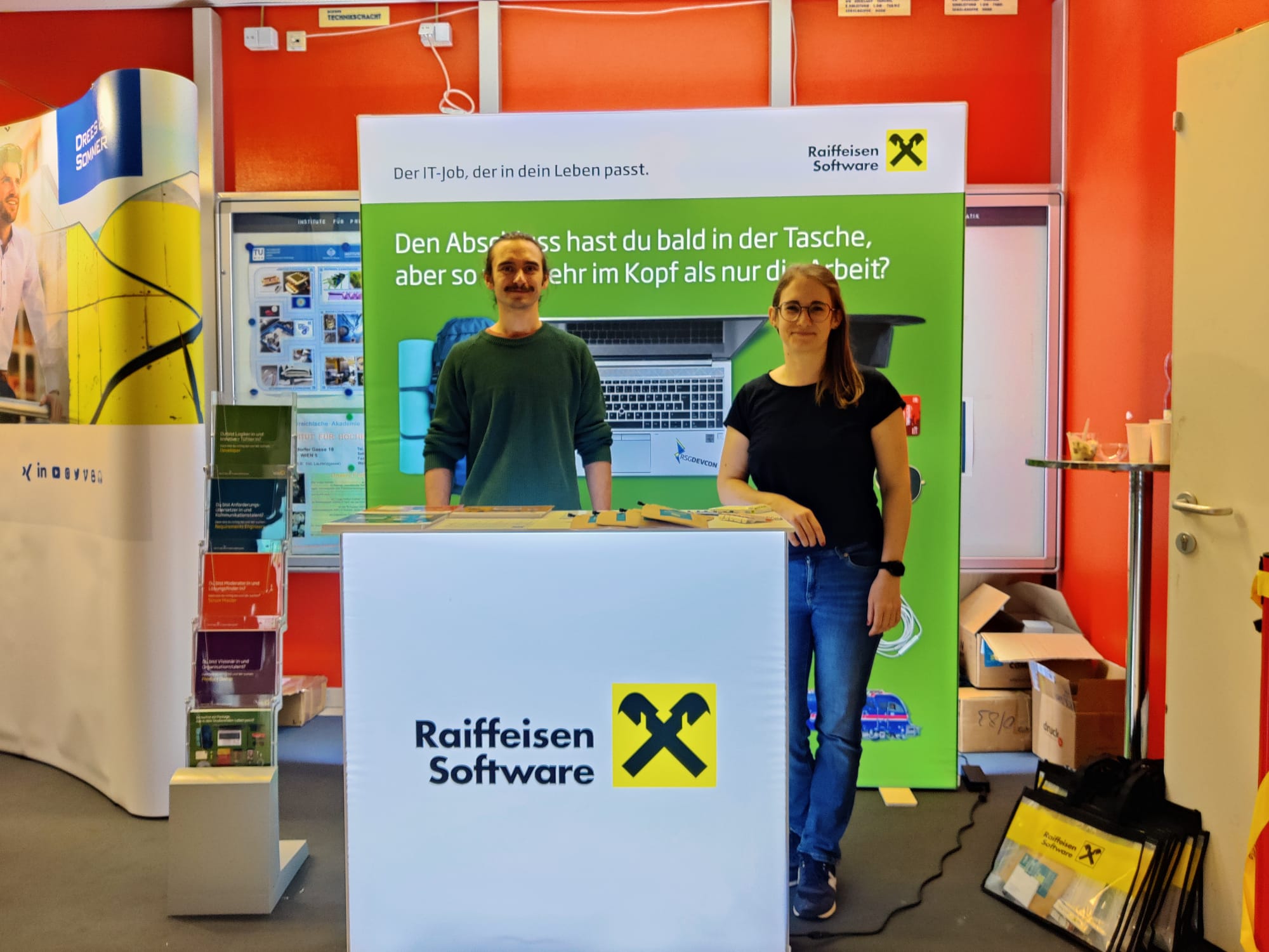 Ein Mitarbeiter und eine Mitarbeiterin am Messestand der Raiffeisen Software